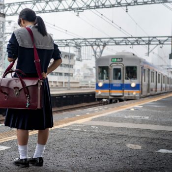 waiting for the train, smartphone and school uniform